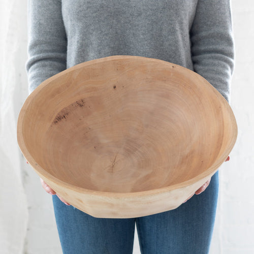 woman holding a large mango wood bowl